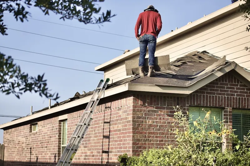 Professional roofer working on a residential roof in Durhamville